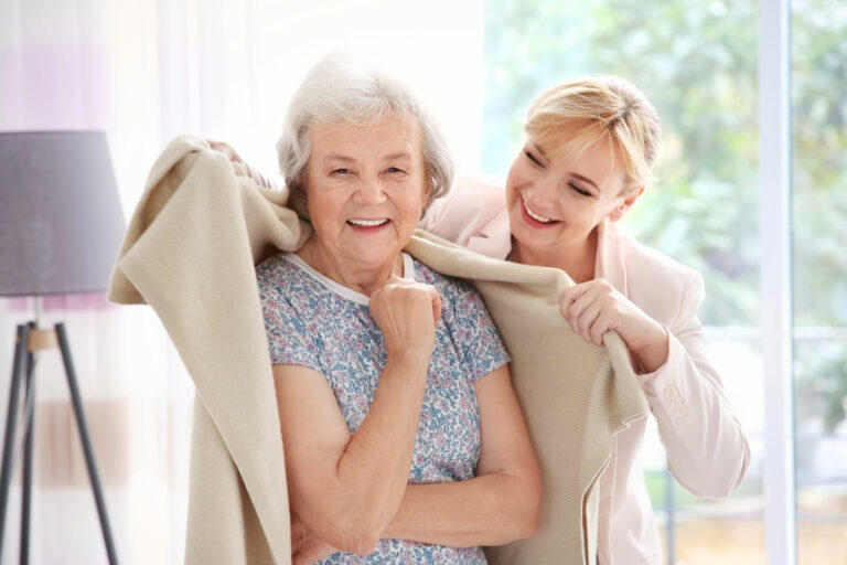 Proveer at Grande View | Caregiver helping senior woman with blanket